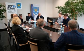 Zdjęcie przedstawiające siedzących przy stole ludzi.